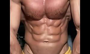 Big muscular body flexes and sprays lotion on his ripped big chest!